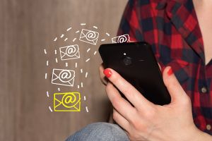 Foto: Frau hält Mobiltelefon in der Hand